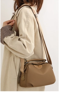 Detail of khaki oxford nylon shoulder bag with adjustable strap and leather logo patch