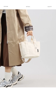 Dettaglio texture della borsa tote in peluche bianco con manici e ciondolo argento