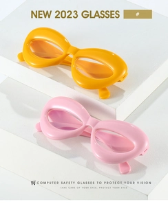 Détail de lunettes de protection ovales épaisses roses et jaunes sur supports géométriques
