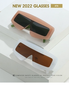 Detail of oversized shield sunglasses with trendy thick frames and gold rivet accents