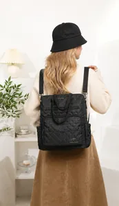 Detailed view of black quilted nylon backpack featuring diamond stitching and kangaroo logo