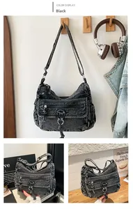 Close-up of black denim multi-layer shoulder bag with vintage metal zippers and texture