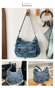 Detail view of the vintage blue denim crossbody bag with multi-layer zipper compartments
