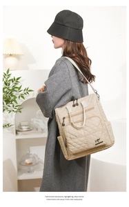 Detail of beige quilted nylon backpack featuring multiple zippers and kangaroo logo