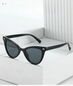 Détail de lunettes de soleil œil-de-chat vintage avec rivets argentés et verres foncés