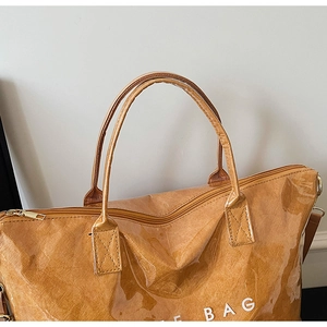 Detail of caramel tote bag with waterproof PVC layer and adjustable shoulder strap
