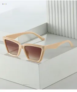 Detail der beigen Cat-Eye-Sonnenbrille mit Silbernieten und braunen Verlaufsgläsern