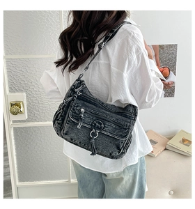 Detail of dark grey washed denim crossbody bag with multiple zippers and cargo style