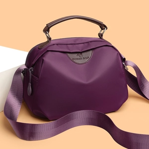 Minimalist purple nylon tote bag with brown leather handles and adjustable shoulder strap