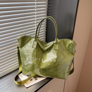 Glossy grass green Dupont paper tote bag with white TOTE BAG text on a windowsill