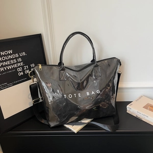 Minimalist black glossy tote bag with white TOTE BAG lettering and wide nylon strap