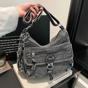 Vintage washed black denim multi-pocket shoulder bag with silver zippers and tassels
