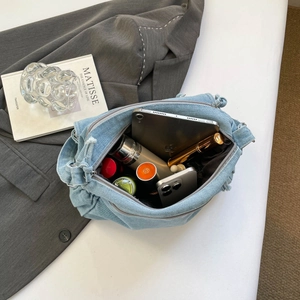 Frayed edge denim shoulder bag with spacious interior showing daily essentials