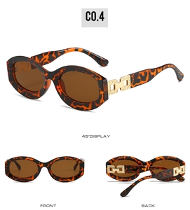 Detail view of oval tortoise sunglasses with golden chain accents and brown lenses