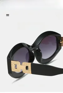 Detail of stylish oval sunglasses featuring black frame and golden hollow metal hinges