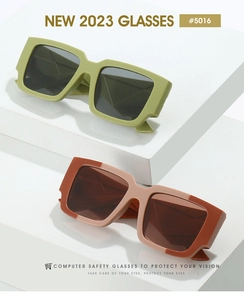Détail de montures carrées géométriques en vert olive et beige avec verres anti-lumière bleue
