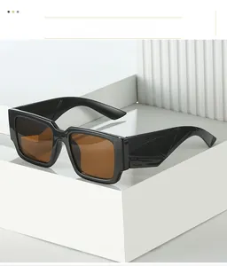 Détail de lunettes de soleil carrées noires avec branches texturées et verres marron foncé