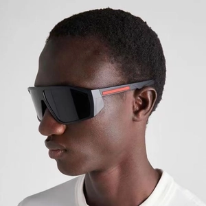 Close-up of sporty oversized wraparound sunglasses featuring iconic red stripe on temples