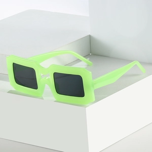 Lunettes de soleil carrées vert fluo tendance avec verres foncés sur un bloc blanc