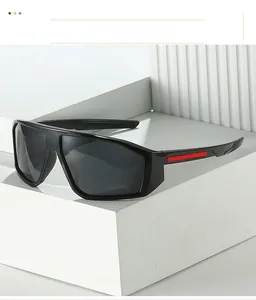 Close-up of black sports sunglasses with grey UV lens and red decorative temple details