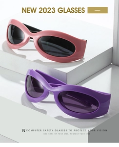Detail of pink and purple Y2K cat-eye sunglasses with dark lenses on a white display