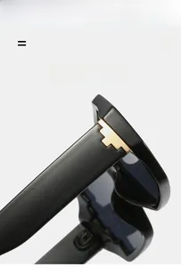 Detail of polygon sunglasses with black frames and a golden T-shaped metal hinge hinge
