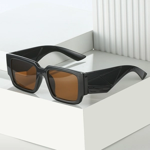 Lunettes de soleil carrées à monture noire et verres marron sur support géométrique