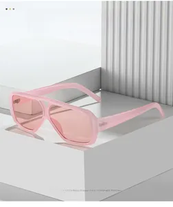 Detailed close-up of pink oversized pilot sunglasses on a geometric platform