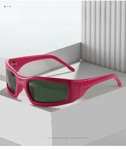 Détail de lunettes de cyclisme rose vif avec verres vert foncé sur un support géométrique