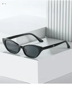 Detailed close-up of modern black cat-eye sunglasses with polished frames on geometric blocks