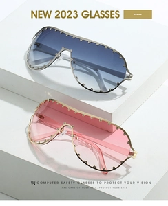 Detail of oversized shield sunglasses with blue and pink gradients and rivet studs