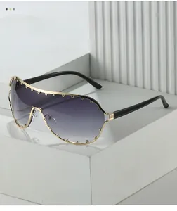 Close-up of oversized gradient lenses with gold rivet studs and metallic frame details
