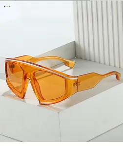 Macro shot of oversized orange cycling sunglasses featuring top white stripe accent