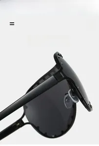 Detailed macro view of black oversized sunglasses with silver rivet studs and glossy finish
