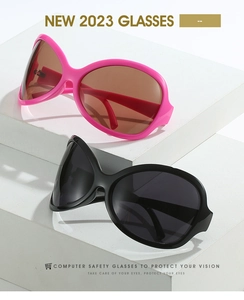 Gros plan de lunettes de soleil hip hop oversize rose et noir sur un présentoir
