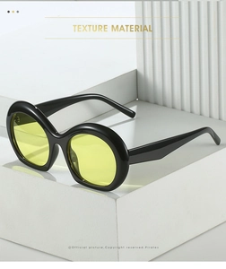 Lunettes de soleil ovales noires avec verres jaunes sur un socle géométrique moderne
