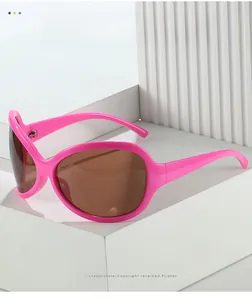 Détail de lunettes de soleil rose oversize avec verres bruns sur socle en pierre