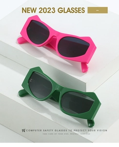Pink and green geometric sunglasses displayed on white minimalist architectural blocks