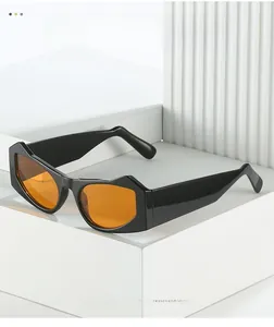 Detail showing thick black geometric frame and vibrant orange lenses of cat eye sunglasses