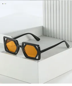Detail of square black frame sunglasses with orange lenses on modern geometric stand