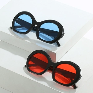 Lunettes de soleil ovales rétro épaisses avec verres bleus et rouges sur socles