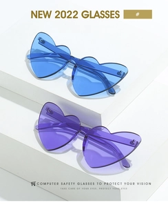 Détail de lunettes de soleil sans monture en forme de cœur bleu et violet sur socle