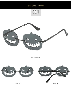 Detail view of Halloween pumpkin sunglasses with hollowed-out face and grey lenses