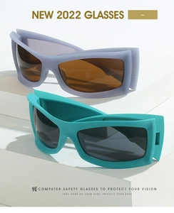 Detail view of purple and teal wrap-around sports sunglasses on white geometric pedestals