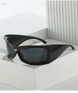 Detail of oversized matte black wrap-around cycling sunglasses on minimalist stone base