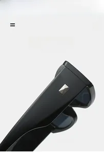 Détail de lunettes de soleil noires avec boucle en métal argenté sur les branches