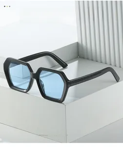 Detailed close-up of geometric hexagonal sunglasses with black frames and light blue lenses