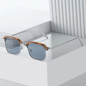 Silberne quadratische Sonnenbrille mit bernsteinfarbenem Brauenbogen und grauen Gläsern