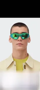 Front view of model wearing futuristic green sports sunglasses with teal mirrored lenses