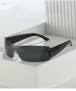 Detail der randlosen Sonnenbrille mit dunkelgrauem Glas und silbernen Sternnieten am Rahmen
